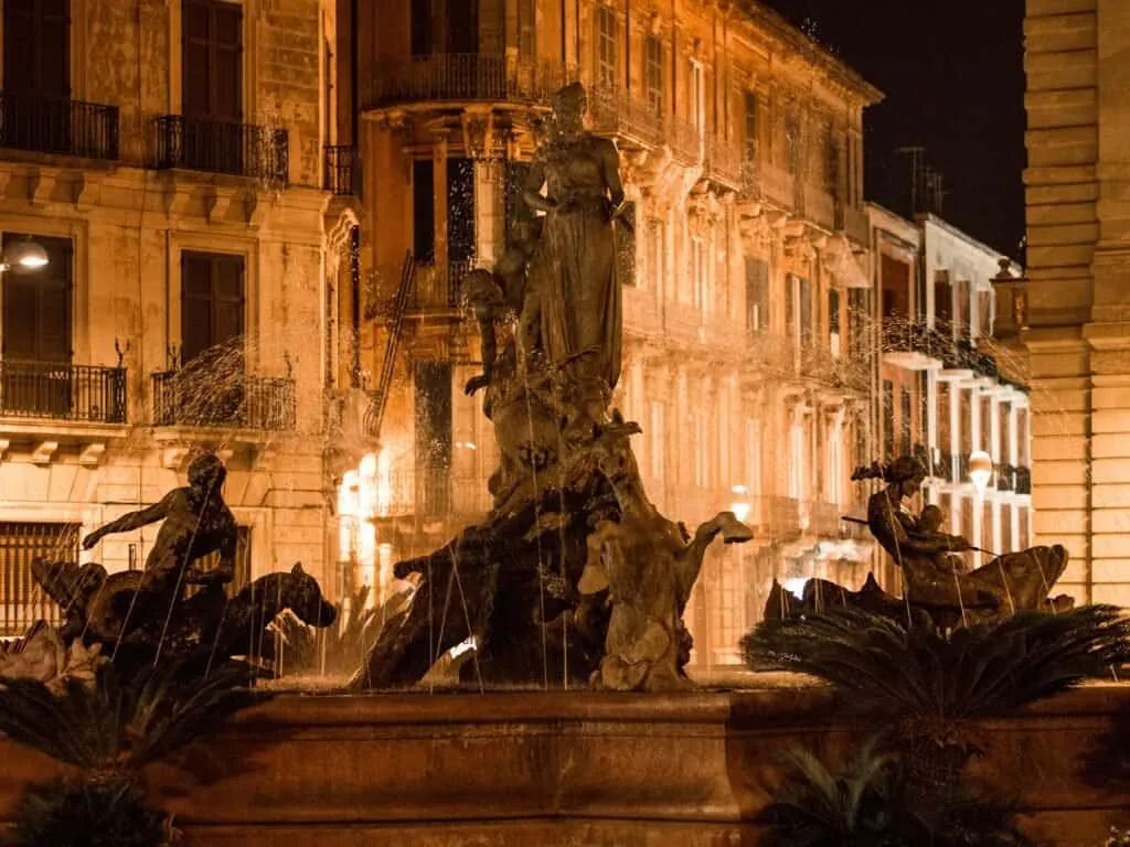 pair The Fontana di Diana lit gold against the palazzi