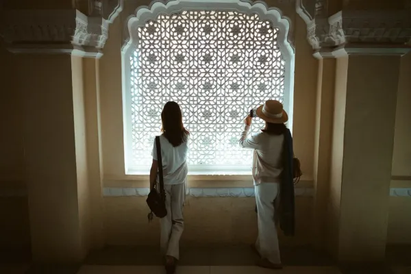 A patterned marble walkway and long side wall of the Taj Mahal receding into dense fog.