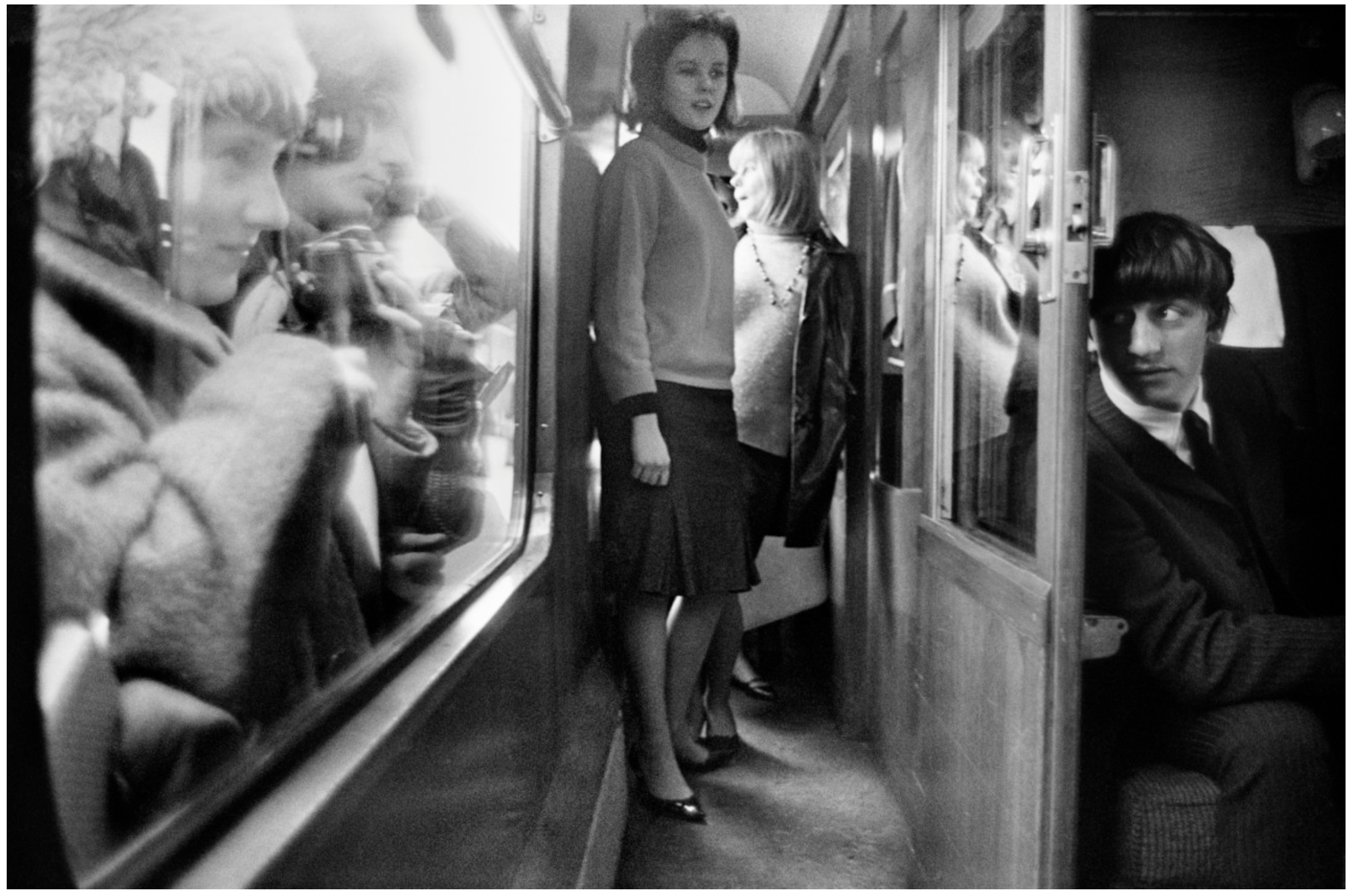 A black-and-white candid photograph on a train